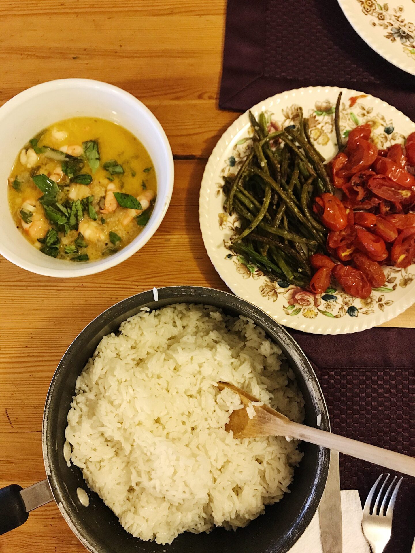 garlic basil shrimp with roasted asparagus and tomatoes and coconut rice on serving dishes