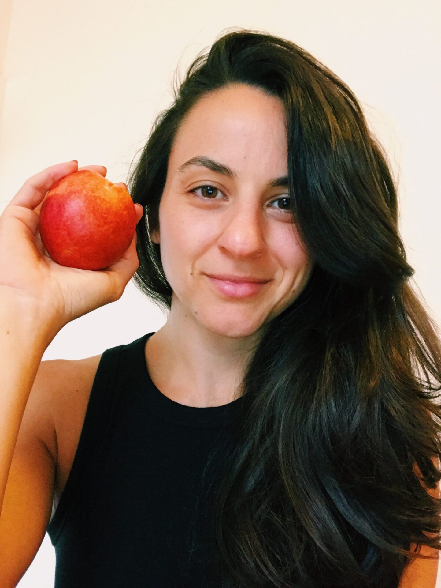 woman registered dietitian nutritionist smiling with nectarine