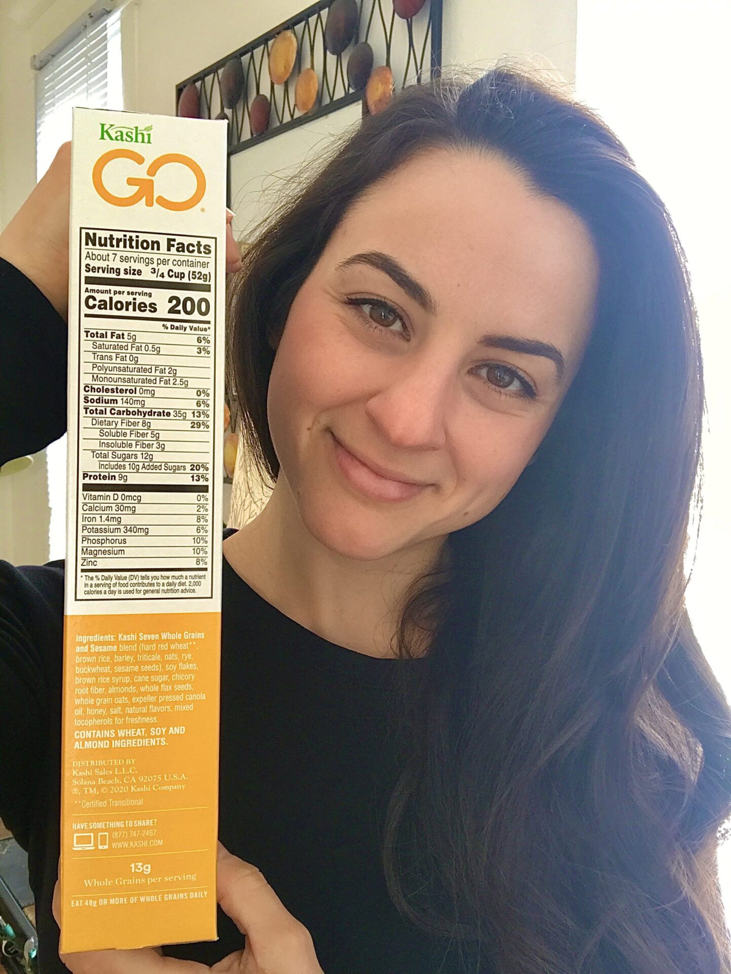 woman registered dietitian nutritionist posing with kashi go lean cereal label