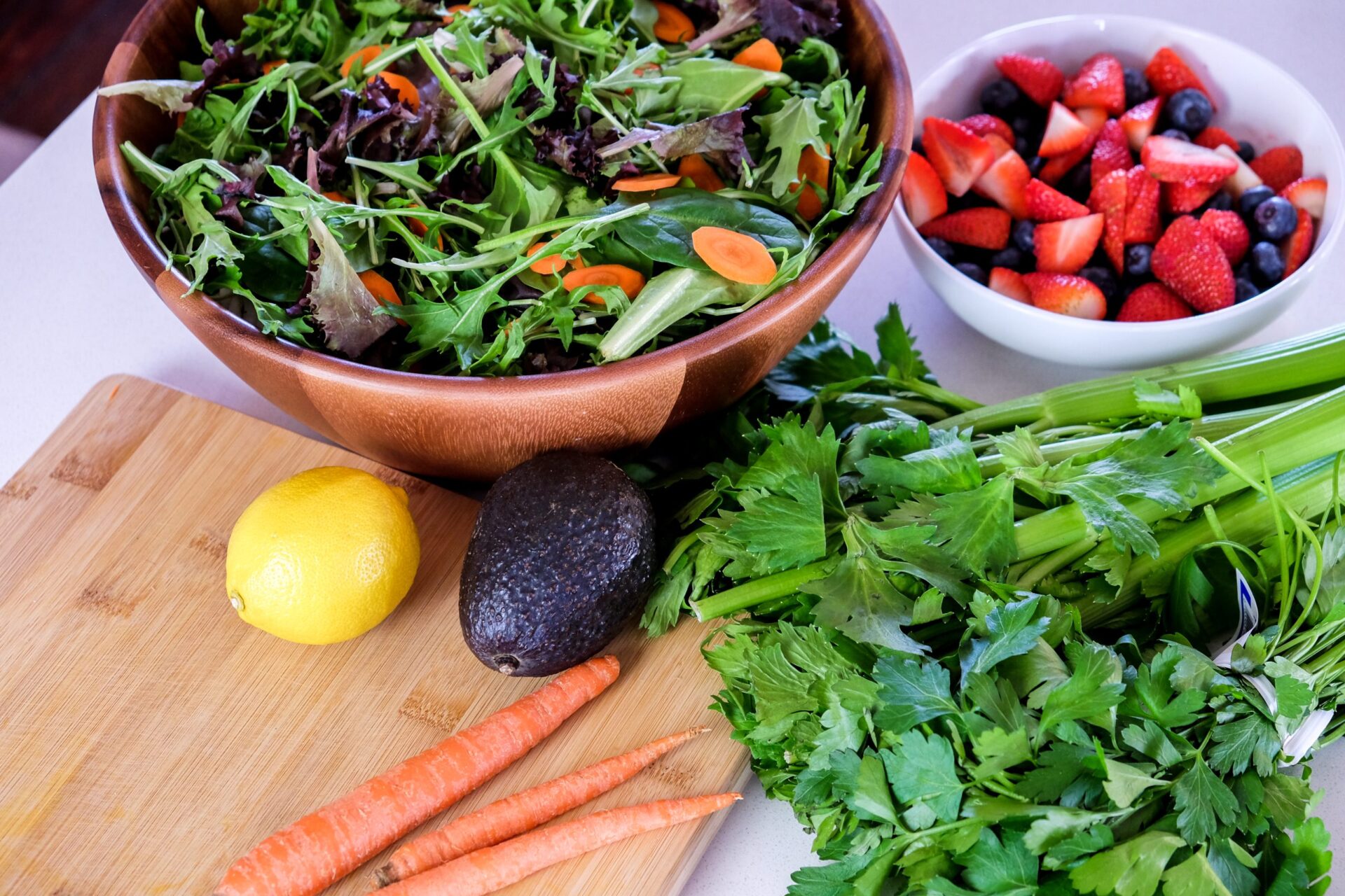 fresh salad greens with avocado carrots lemon celery and berries