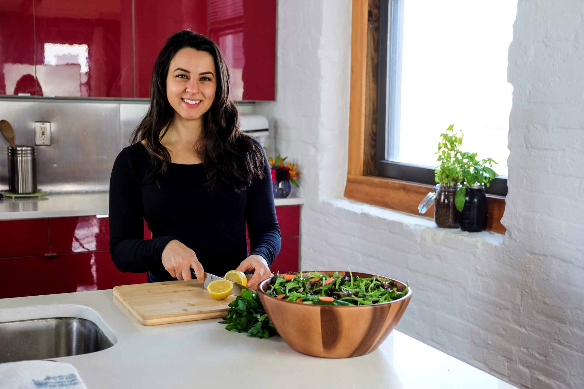 woman smiling and working in bright kitchen